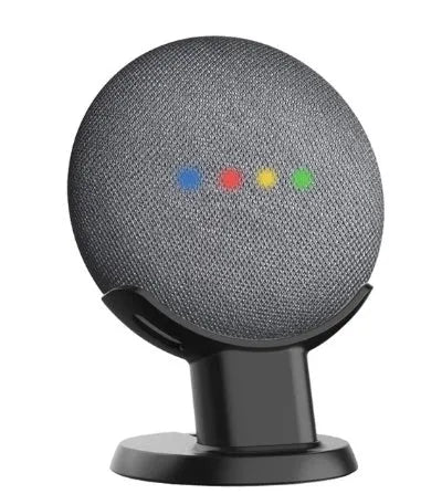Black PlusAcc plastic stand holding a white Google Home Mini smart speaker on a wooden tabletop.