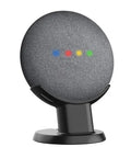 Black PlusAcc plastic stand holding a white Google Home Mini smart speaker on a wooden tabletop.
