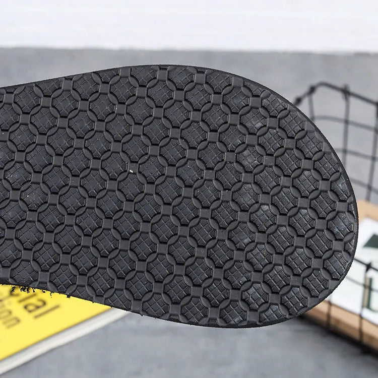 Women's brown bohemian slippers with elastic EVA upper and rubber sole on a wooden floor.