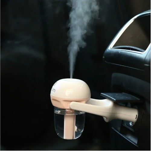 Compact blue portable car humidifier and essential oil diffuser with rotating nozzle on a car dashboard.
