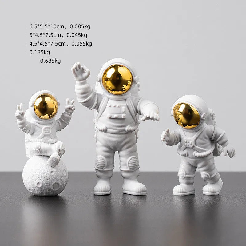 Three resin astronaut figurines for car dashboard decoration, gold finish, placed on dashboard