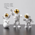 Three resin astronaut figurines for car dashboard decoration, gold finish, placed on dashboard