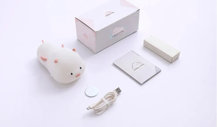 Blue silicone pig-shaped night light with sleeping design and USB charging port