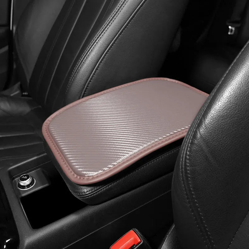 Carbon fibre pattern leather car armrest cushion mat in black, shown on a car centre console.