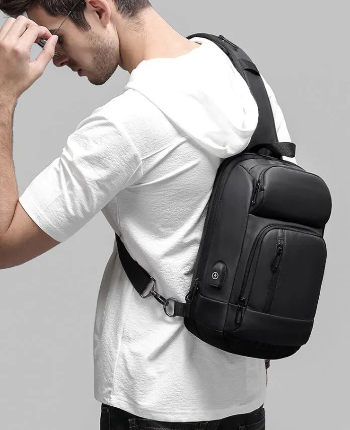 Black PVC outdoor shoulder bag with zipper, internal pockets, and an air cushion shoulder strap.