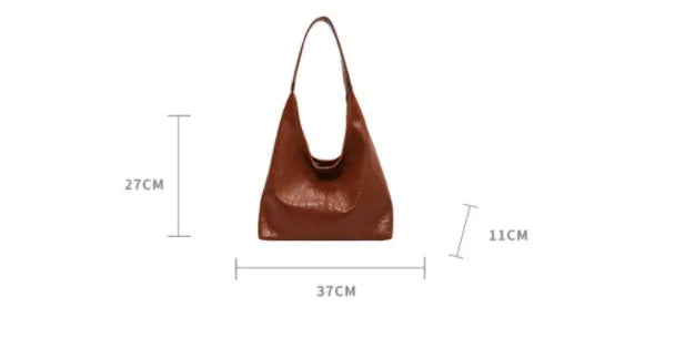 Soft black PU leather shoulder bag with large compartment and adjustable strap on a plain background.