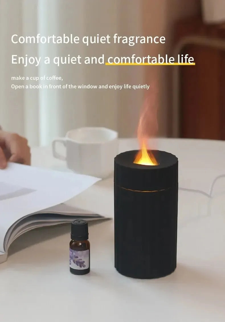 Black and white flame effect essential oil diffuser and air humidifier with coloured LED lights on a wooden table.