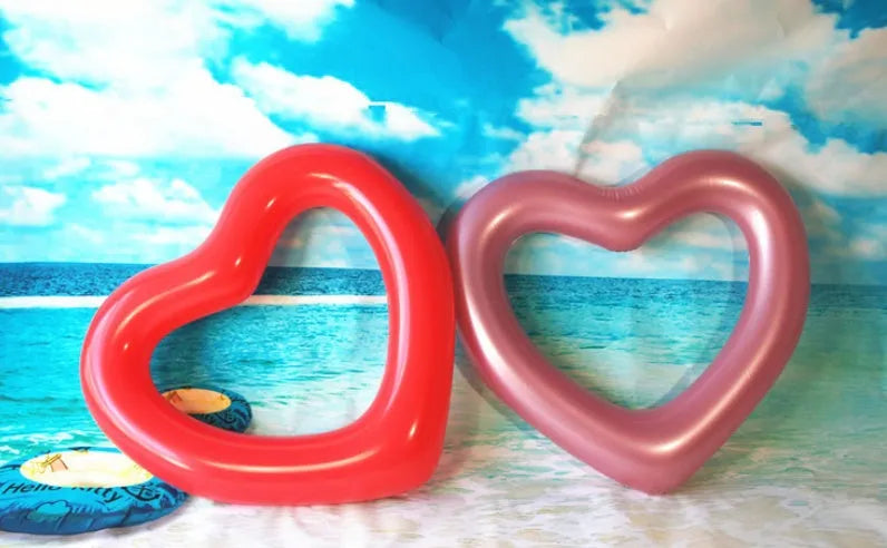 Oversized 120cm heart shaped swim ring in pink floating on water, adult outdoor pool toy