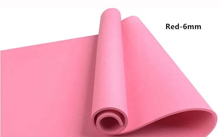 Red EVA fitness yoga mat with rolled edge showing thickness, laid flat on a wooden floor.