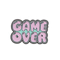 Stereo game console metal alloy badge with pin back, shown in available colours on a backpack strap
