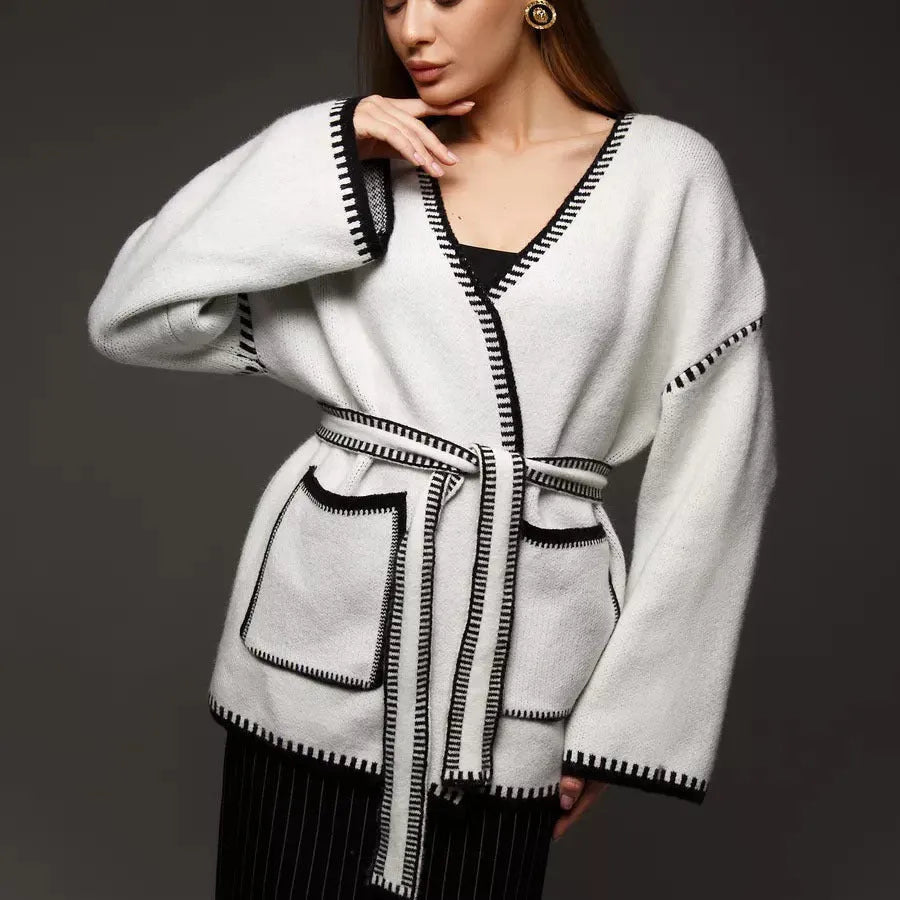 Loose black lace-up knitted cardigan sweater coat with long sleeves.