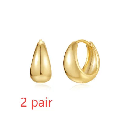 A pair of gold tone geometric earclip earrings with a round design and screw-back mechanism.