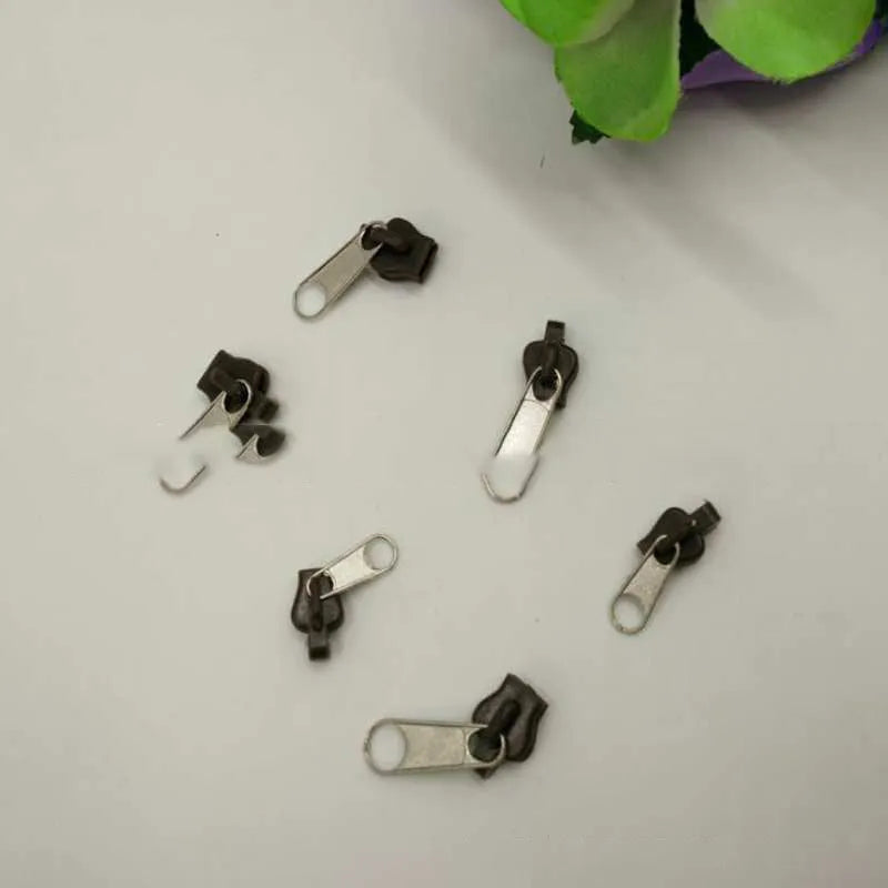 Pack of 12 reusable zipper head slider clips in assorted colours for repairing broken zippers.