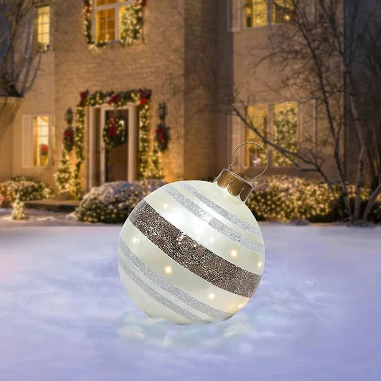 Large red and white striped inflatable Christmas ball ornament hanging on an outdoor tree