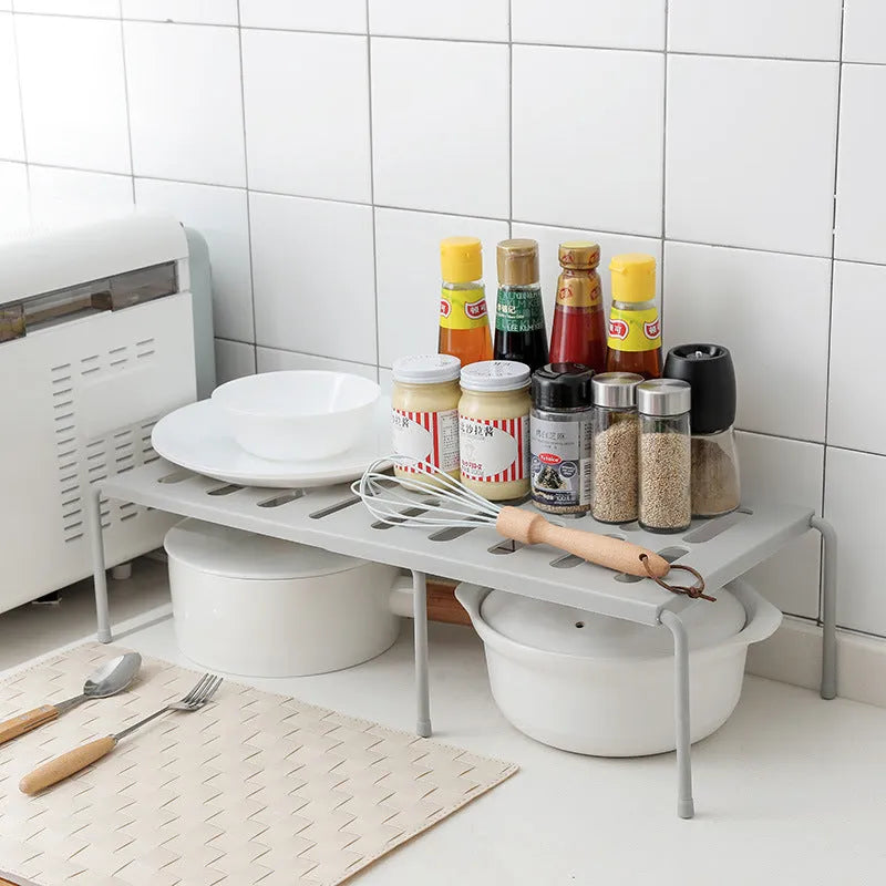 White telescopic kitchen rack with adjustable height showing extended and compressed positions