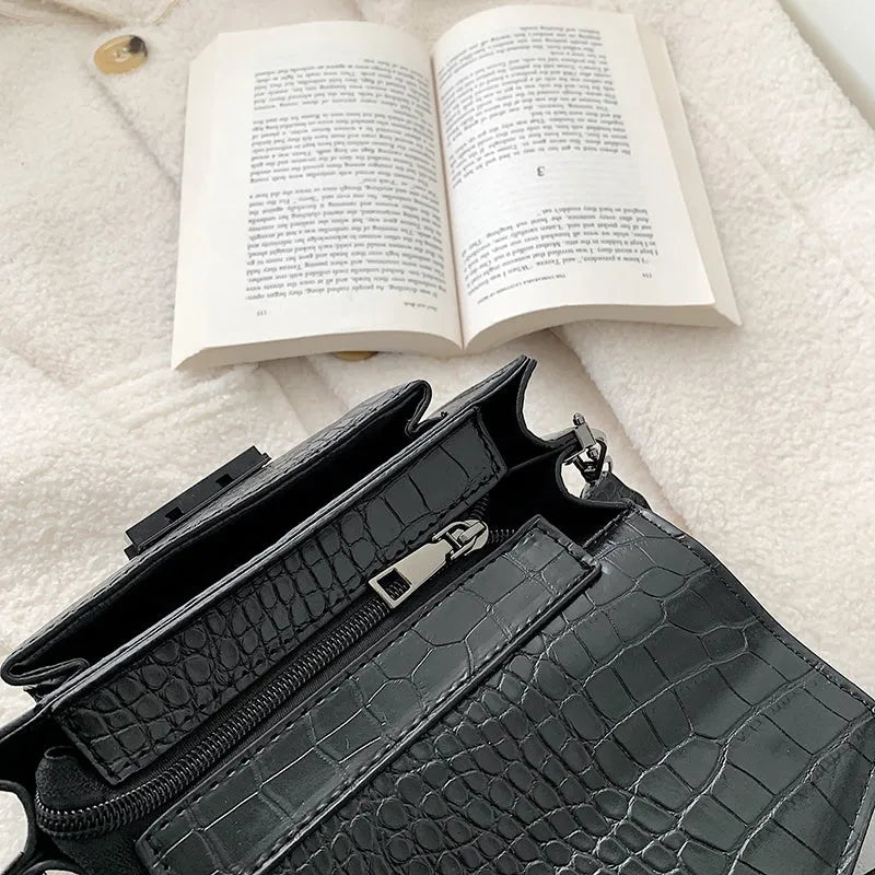 Vintage PU leather crossbody bag in black, shown with a mobile phone and wallet inside