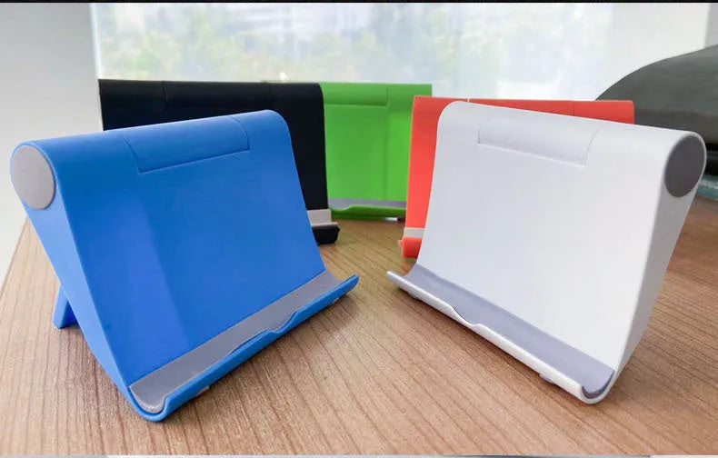 Black PE folding stand holding a smartphone at an angle on a wooden table.
