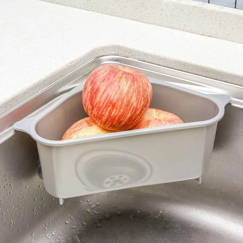 Beige plastic triangle sponge drain rack hanging from a kitchen faucet.
