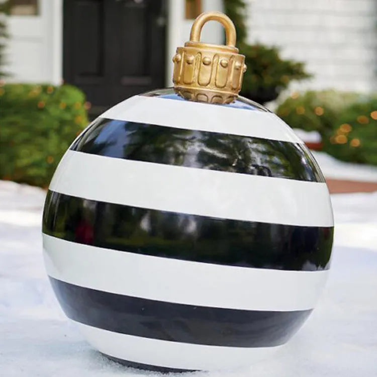 Large red and white striped inflatable Christmas ball ornament hanging on an outdoor tree