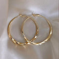 Twisted eyelet simple metal earrings in 3499 Gold and 3499 Silver on neutral background