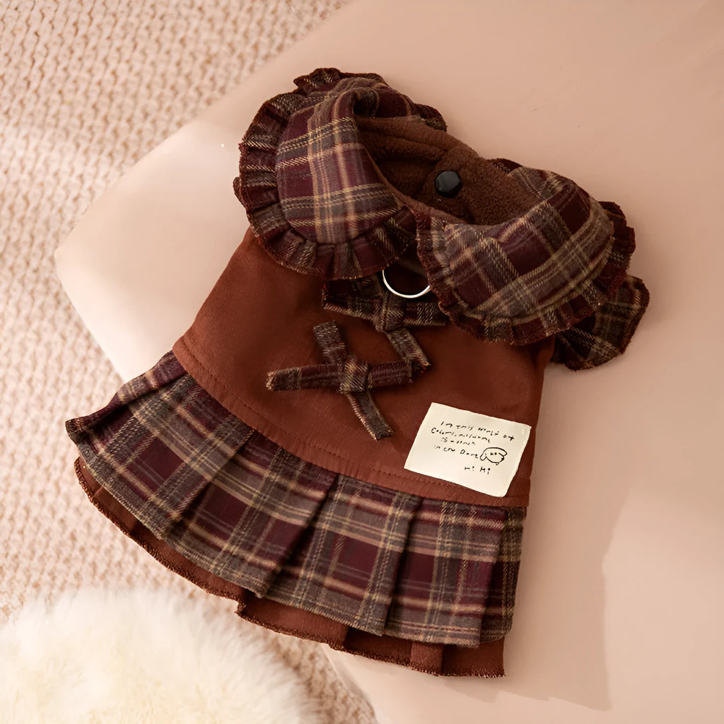 Fleece-lined brown plaid pet sweater dress with ruffle trim on a small dog, showing stretchable knit and skirt silhouette