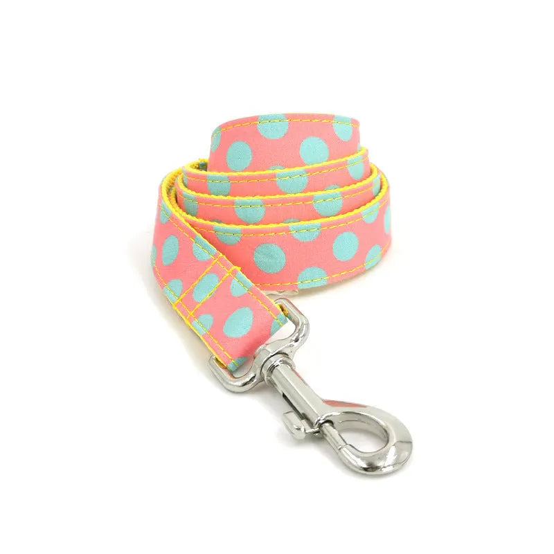 Yellow polka dot dog collar with bow and matching lead rope set on a white background.