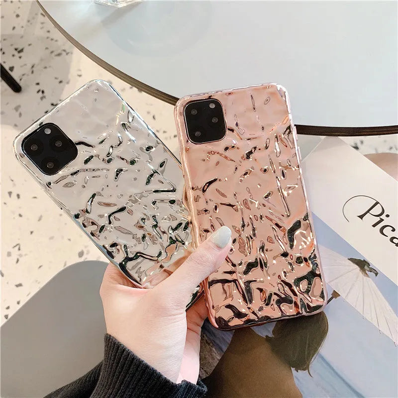Rose gold and silver folded TPU back cover cases for various iPhone models on a plain surface.