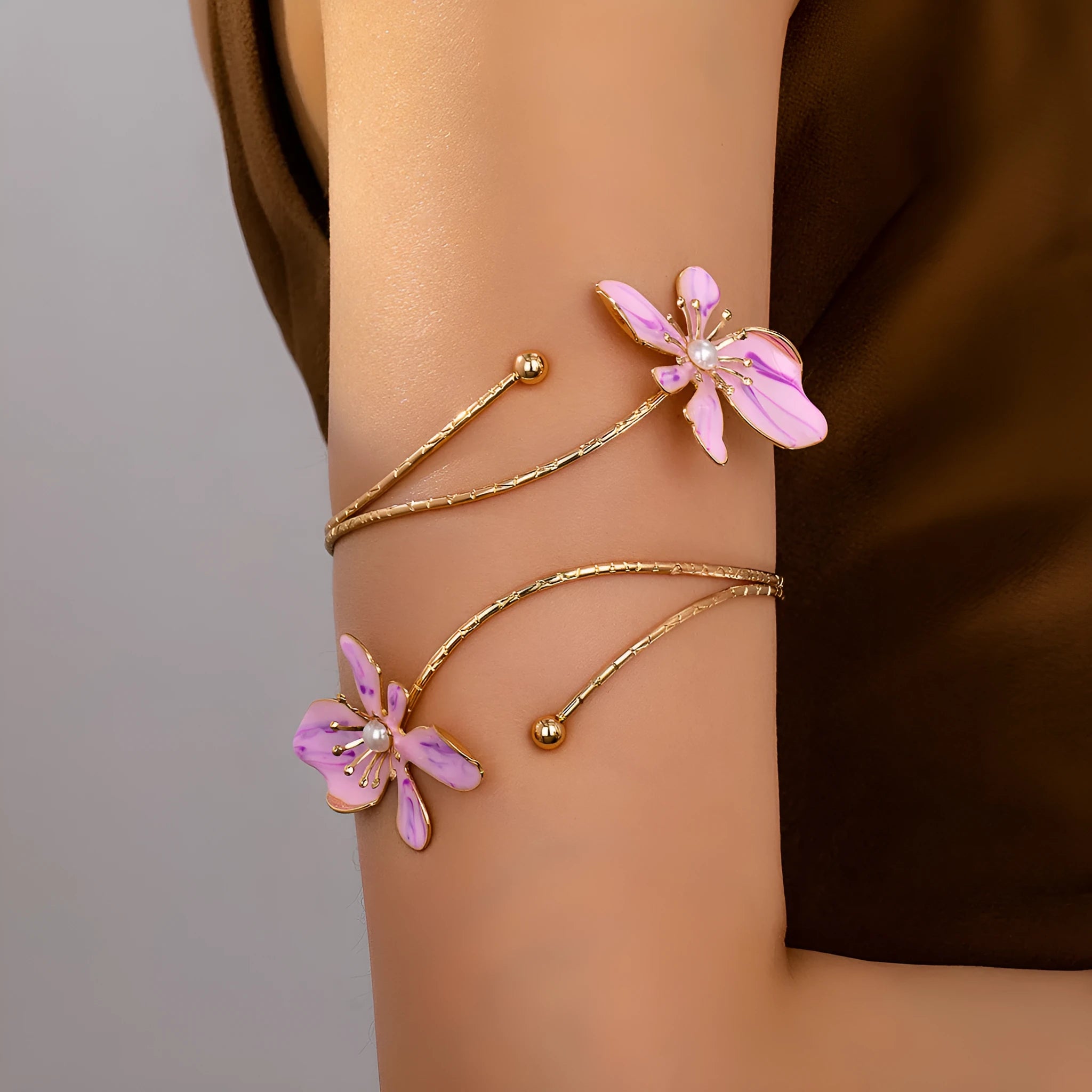 Close-up of a pink alloy arm ring with a hollow line pattern, shown on a wrist.