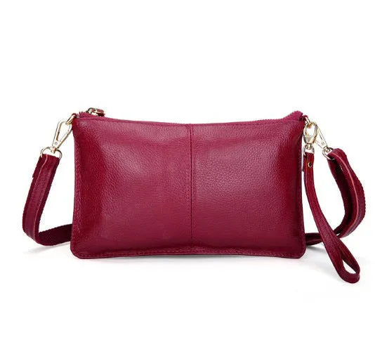 Lady's cowhide leather slant bag in apricot colour with hand strap and shoulder strap showing zipper compartments
