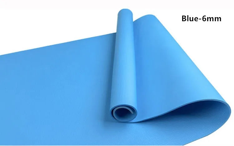 Red EVA fitness yoga mat with rolled edge showing thickness, laid flat on a wooden floor.