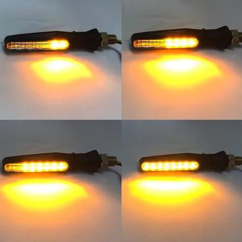 Black universal motorcycle flowing water LED turn signal indicator with flexible rubber section and amber lights on a dark background