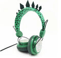 Green dinosaur children's headset with soft earmuffs and 3.5mm plug on a plain background