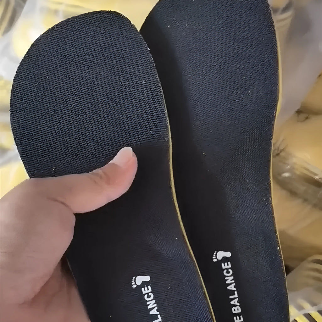 Pair of black soft sports shock-absorbing polyester insoles on a light background