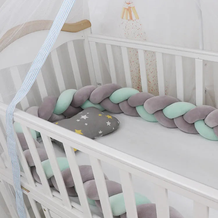 Baby cot bumper braid in spandex crystal velvet, shown in a light grey colour, wrapped around white crib rails.