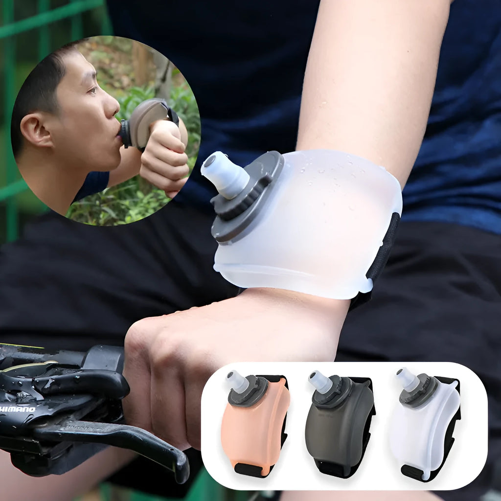 Black silicone wrist water bottle with orange Velcro strap secured around a wrist, showing bite valve.