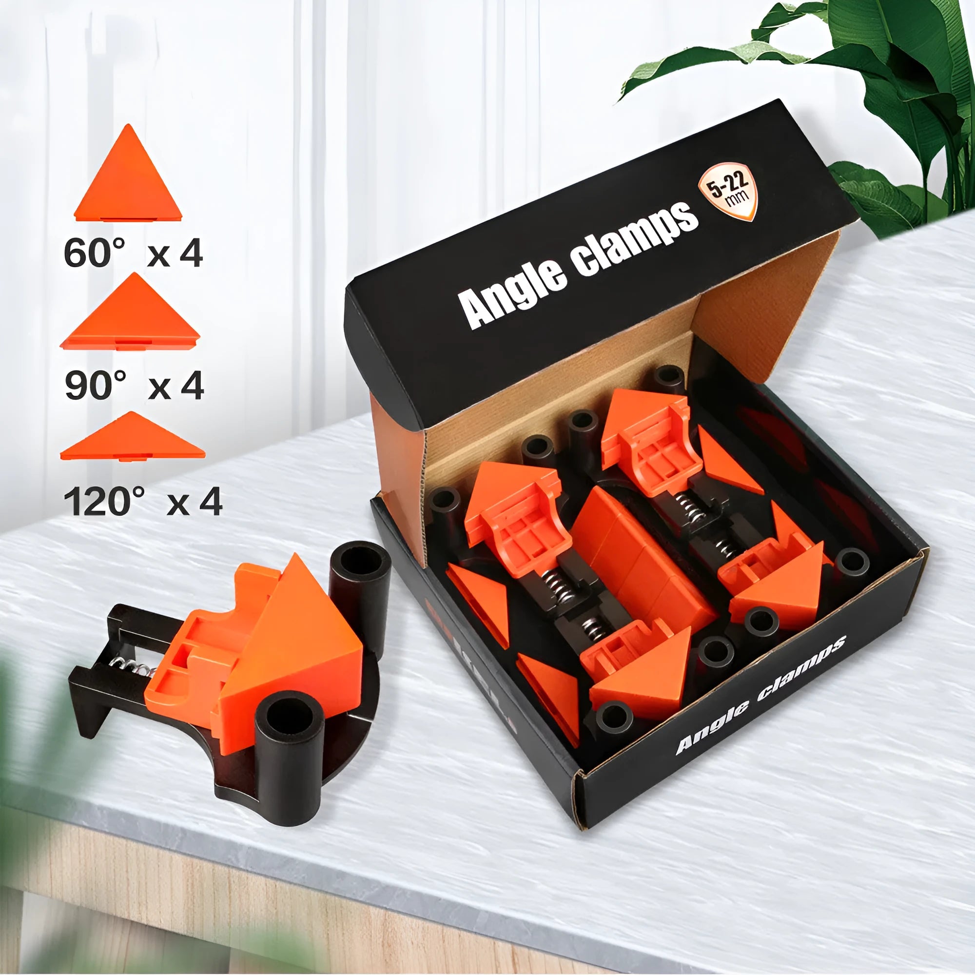 Set of four white plastic right angle clamps for picture frame assembly on a wooden surface.