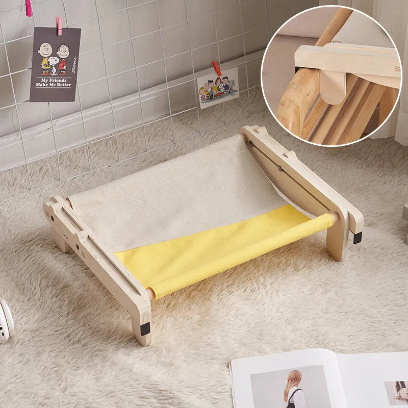 Solid wood cat bed with a removable plaid cushion on a wooden frame.