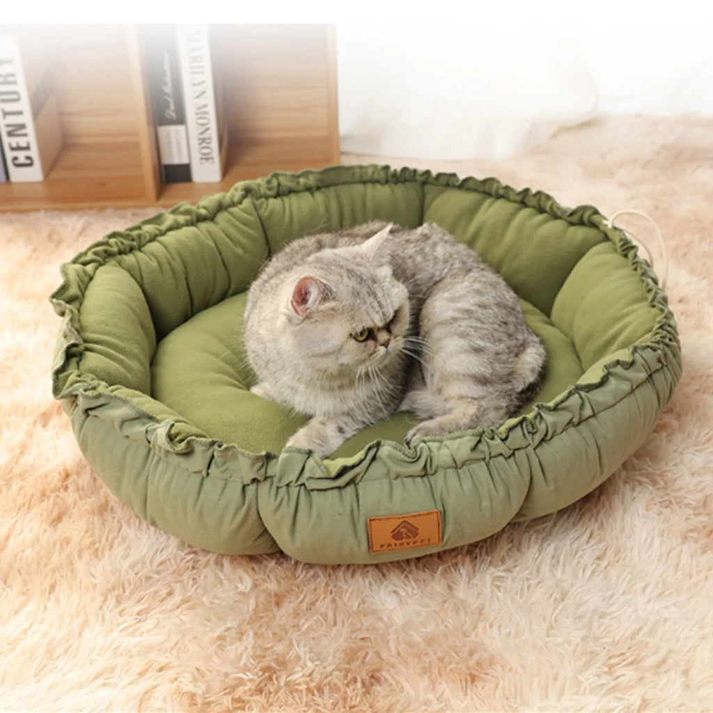 Grey and green reversible donut-shaped pet bed for cats and small dogs on a wooden floor.