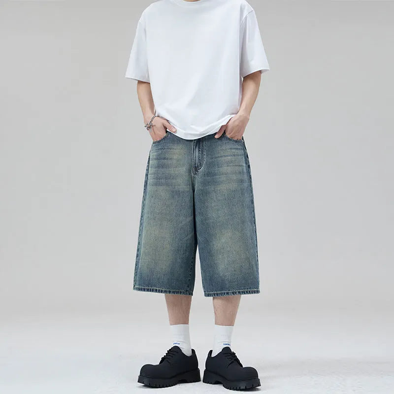 Men's loose straight denim shorts in light blue, cropped length, flat lay