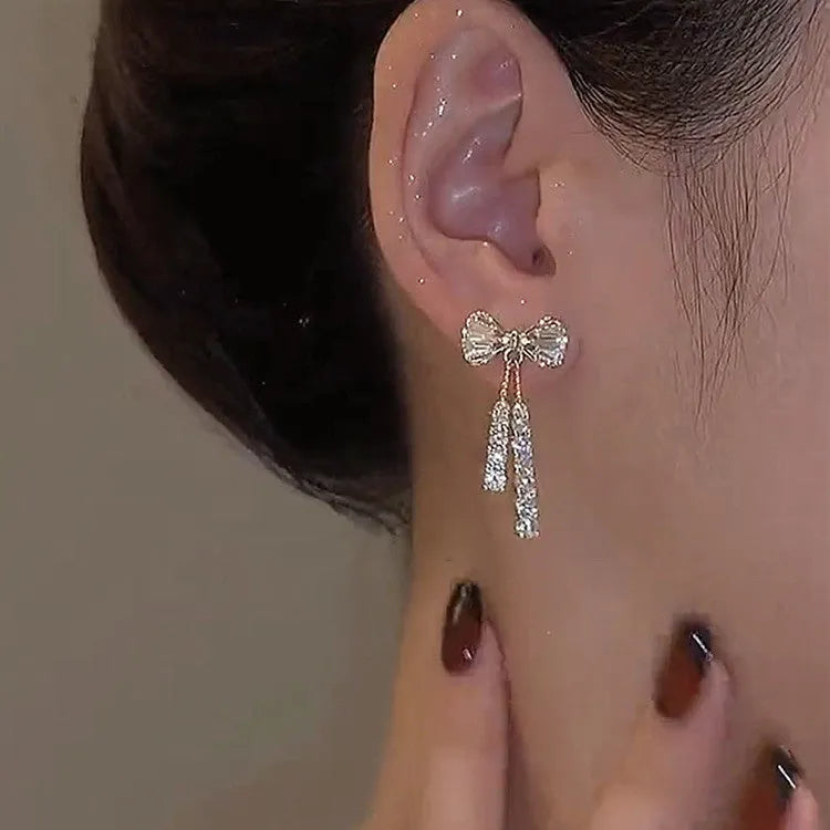 Gold butterfly earrings with rhinestones and bow element on alloy base