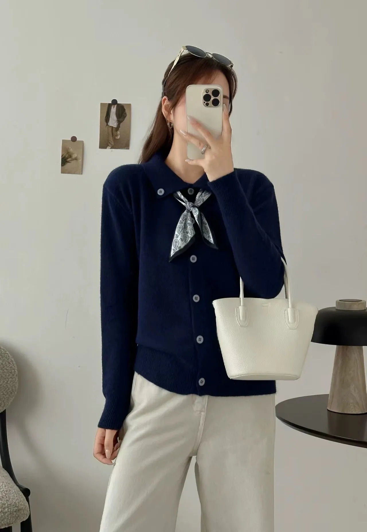 Milky white acrylic fibre cardigan sweater with a lapel scarf and long sleeves laid flat