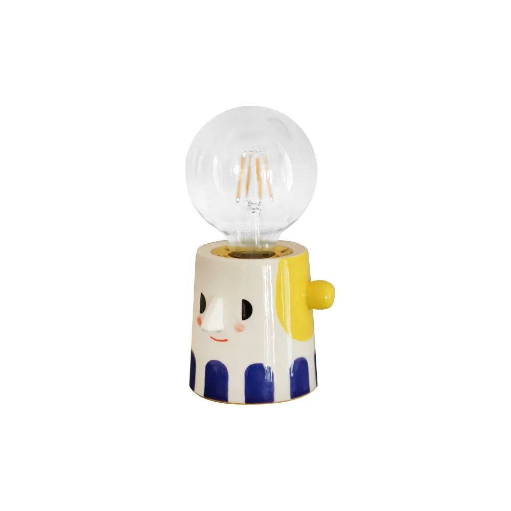 Handmade ceramic table lamp with a white ball headlight shade on a wooden table.