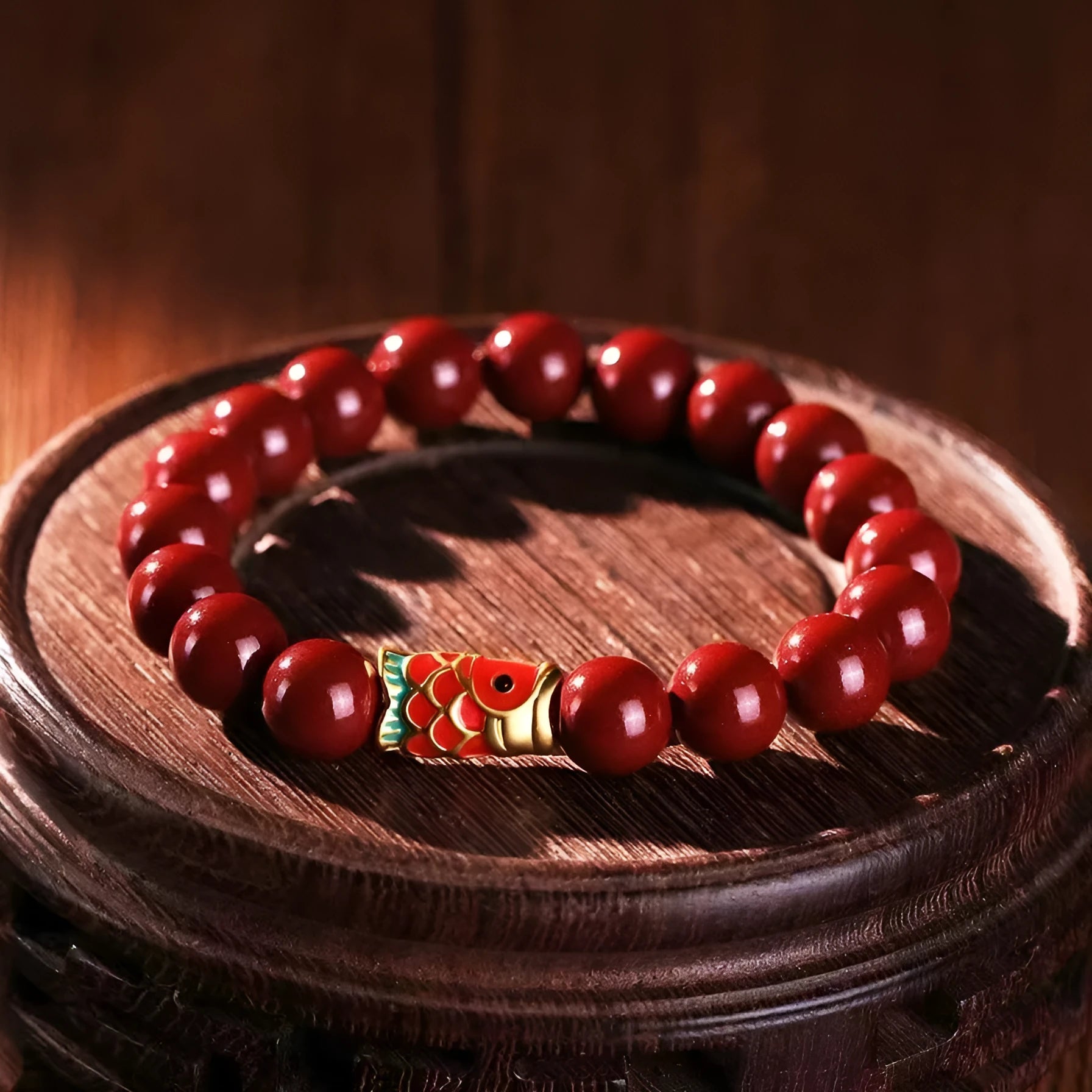 Natural cinnabar koi bracelet with golden ball in national style on a wrist.