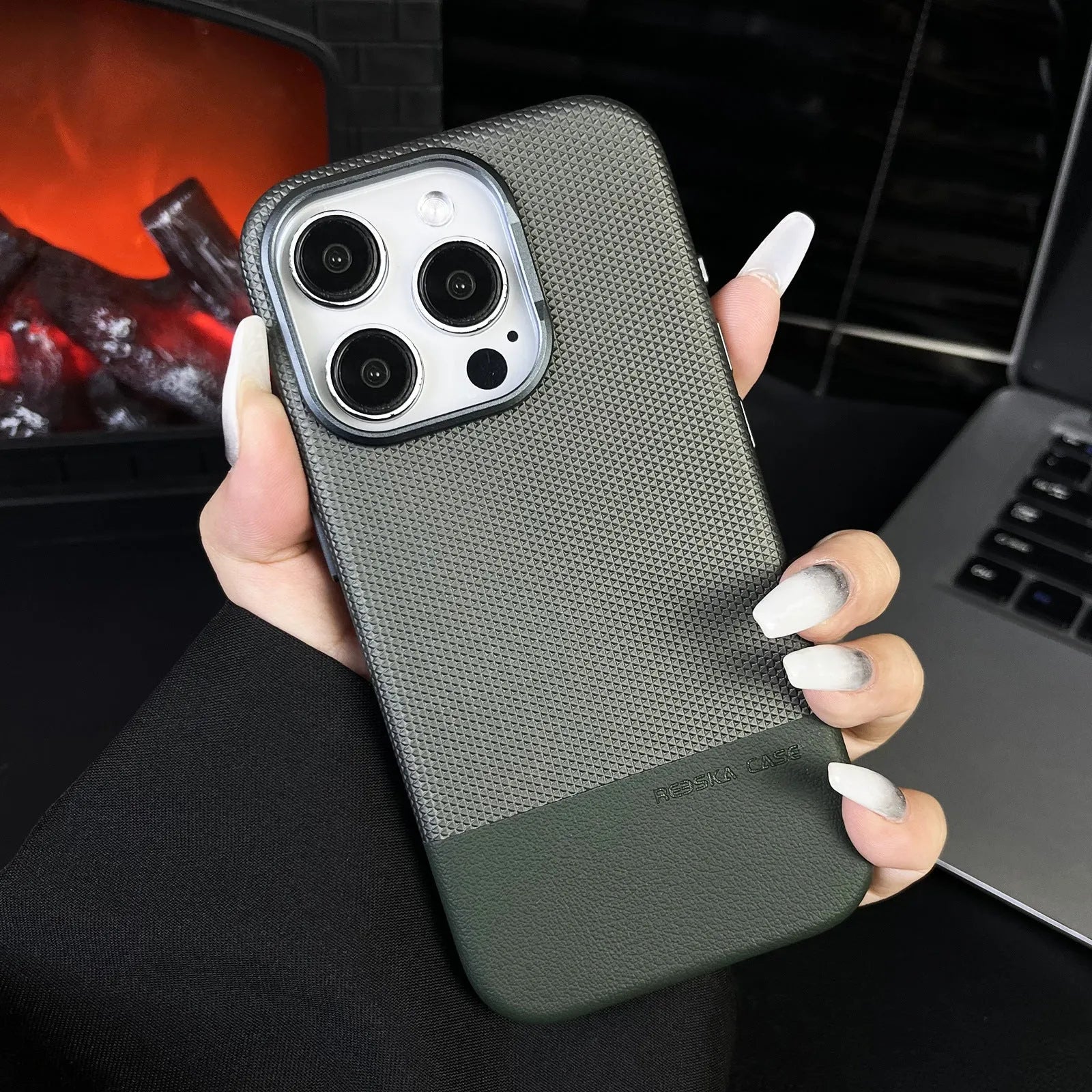 Black magnetic iPhone case with dragon scale texture and stitching, shown on an iPhone.