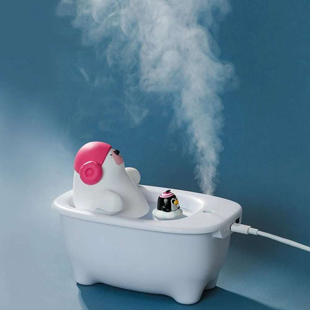 White plastic USB desktop air humidifier and essential oil diffuser on a wooden table.