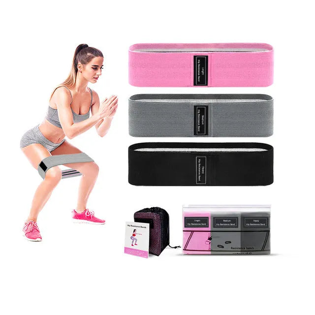 Set of three fabric resistance bands in lake blue, pink, and purple with a white storage net bag.