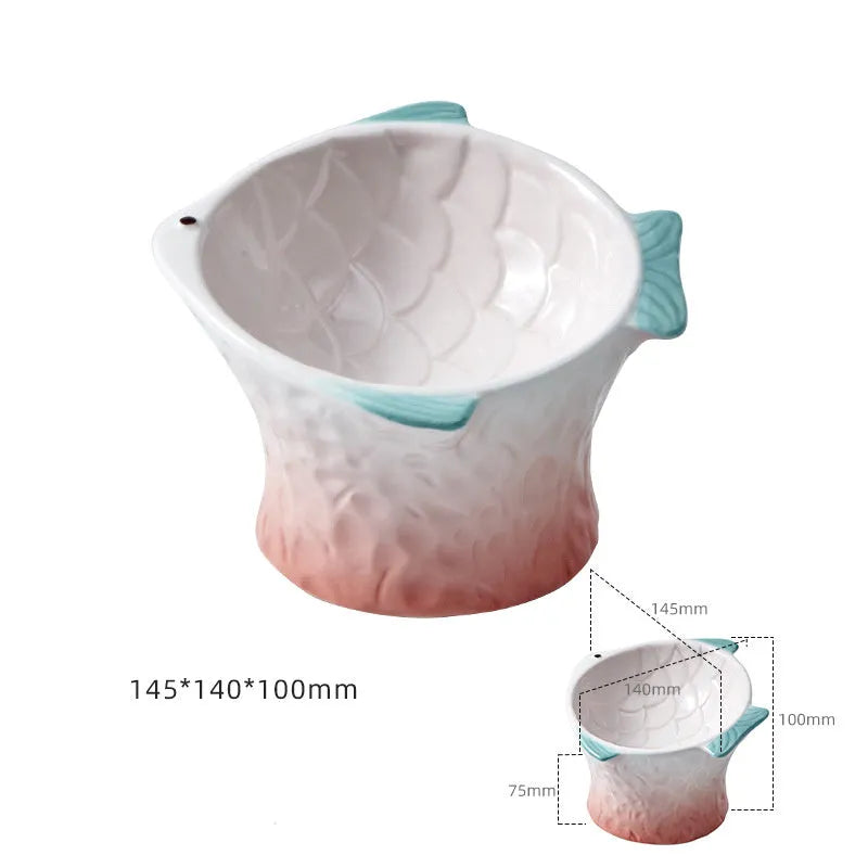 Set of four blue fish-shaped ceramic cat bowls with tilted, elevated design on a table.