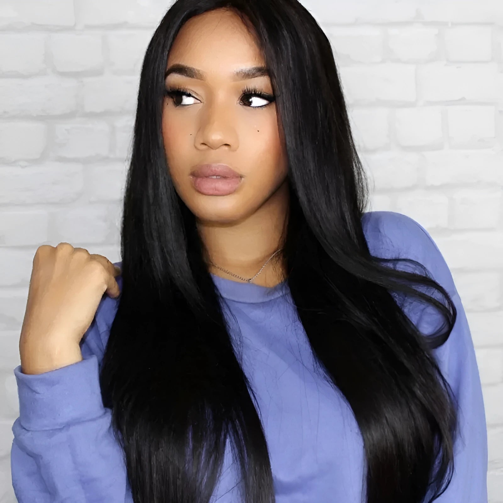 Long straight black synthetic wig with centre-parted bangs on display