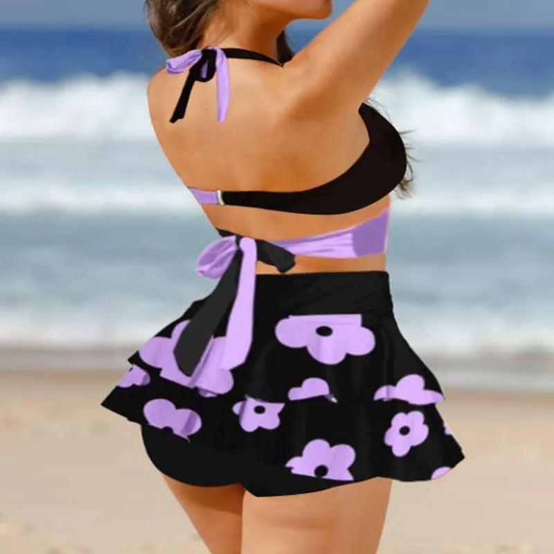Women's black lace-up bikini top with matching high-waist swim skirt laid flat.
