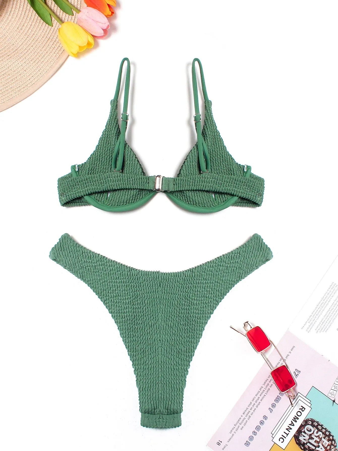 Women's solid green bikini suit with ruffle detailing and split-front design on mannequin